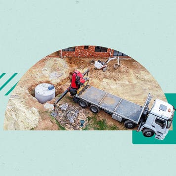 Shot of a flatbed near a septic that has been dug up and is being serviced.