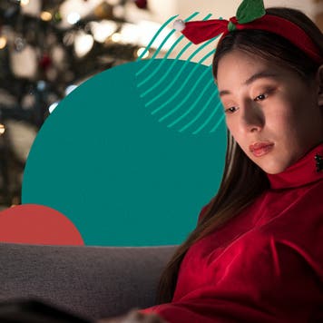Young woman reading a tablet in a holiday decorated living room