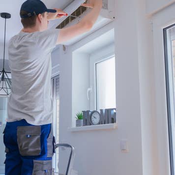 technician repairing air conditioner
