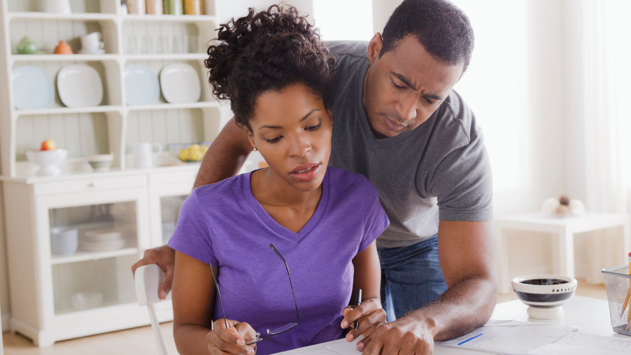 Married couple looking at paperwork with concern on their faces