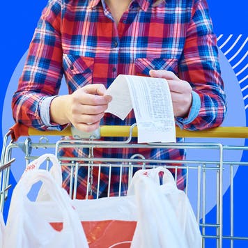 Someone reading a receipt as they push their shopping cart
