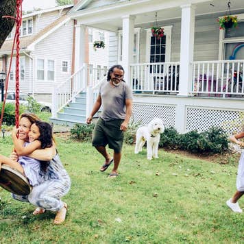 Happy family playing in front year at home