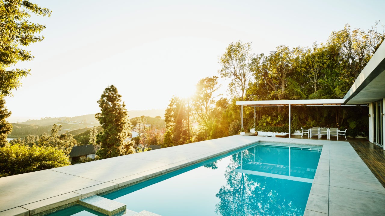 A pool in the backyard of a home during sunset