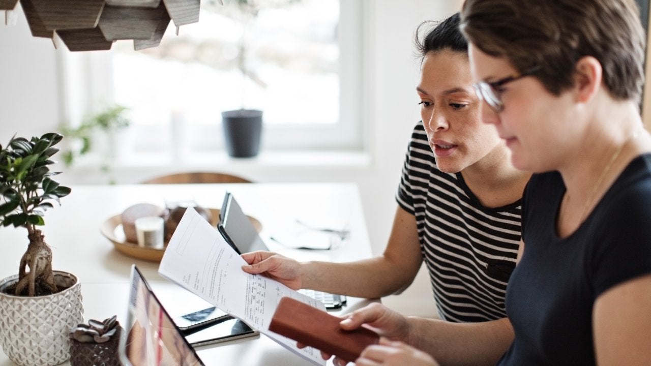 Lesbian couple discussing over financial bills while using laptop at table