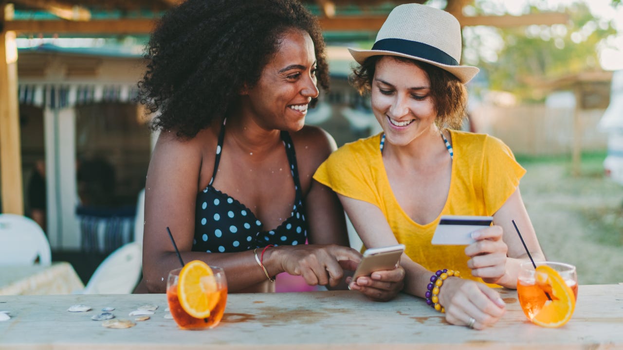 Happy women on beach holiday shopping online