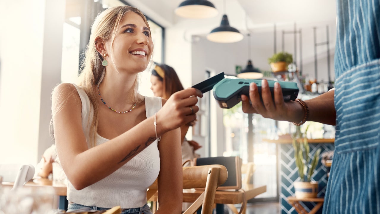 Young woman paying with a credit card at a restaurant.