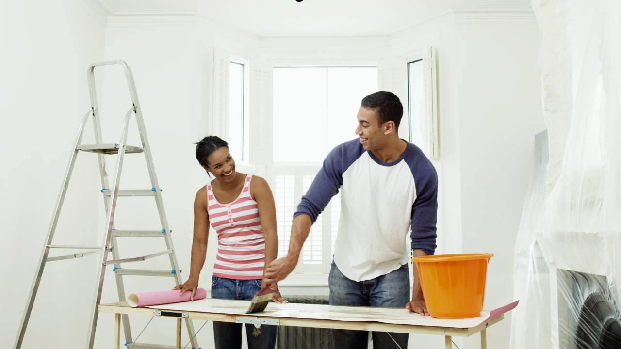 Man and woman preparing to hang wallpaper