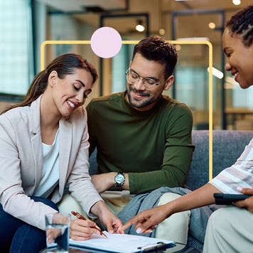 Two people signing documents with an agent