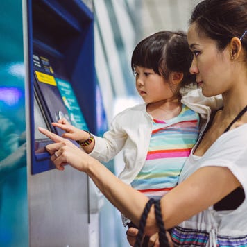 mother at bitcoin atm with toddler