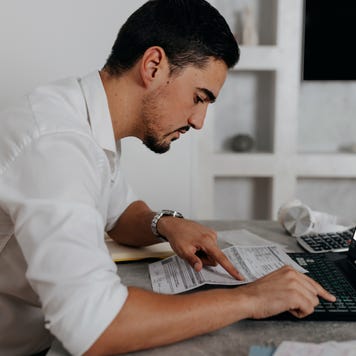 A serious Caucasian man paying bills online