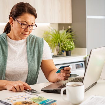 Concentrated woman calculating home expenses