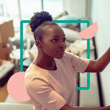 Black woman hanging a photograph on a wall