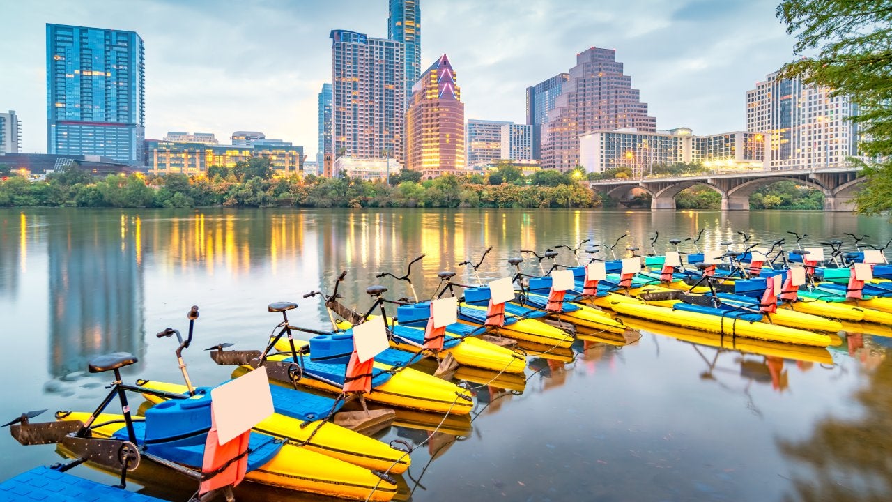 Water Bikes in the Colorado River and the skyline of Austin, Texas, USA at night.