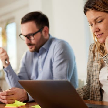 Young business couple working on computers at home office.