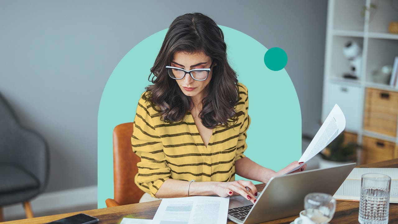Woman looking at documents in front of the computer
