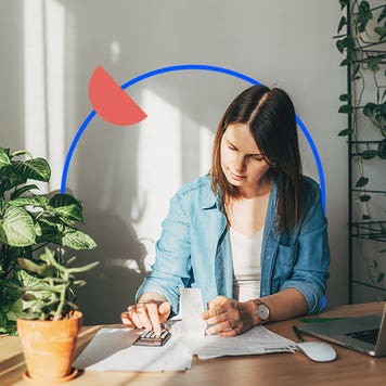 Woman reading papers on table with an illustrated blue circle behind her and an illustrated filled in orange half circle on that circle