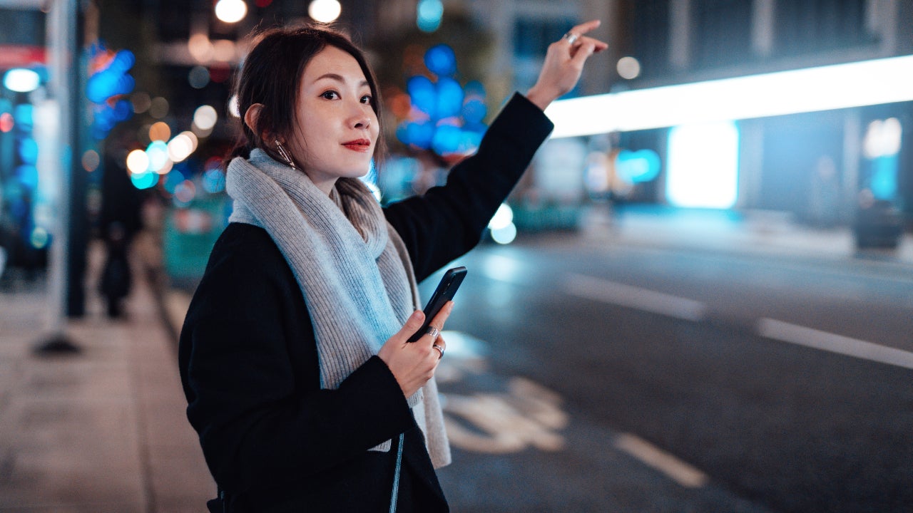 Young Woman With Smartphone waiting for Lyft ride