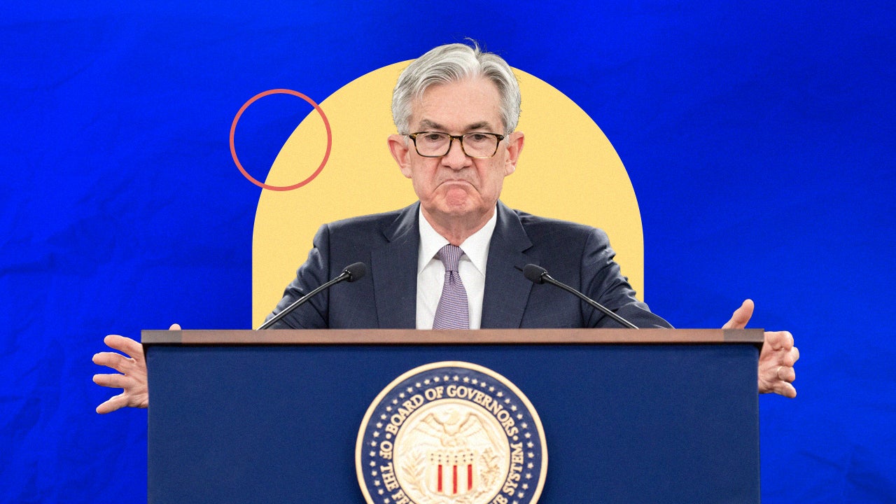 Jerome Powell at frowning while standing at podium