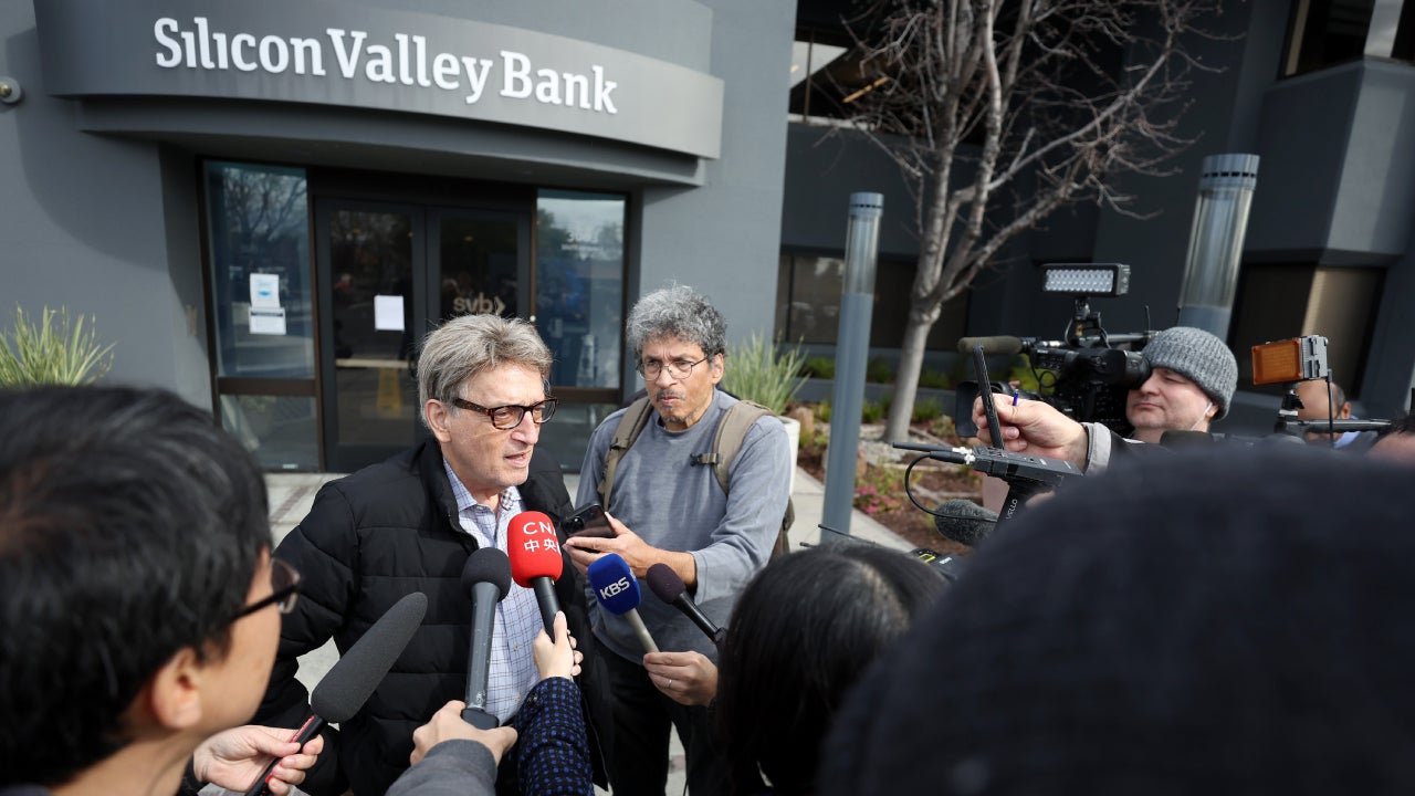 Members of the media interview a Silicon Valley Bank customer outside of the bank office