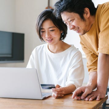 Asian couple using a credit card for internet shopping