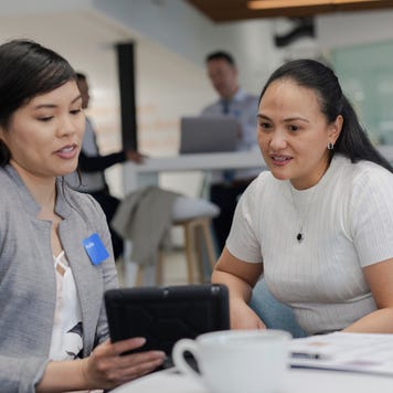 Two women discussing documentation in an office
