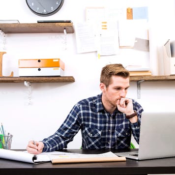 Man sitting at desk with laptop and documents