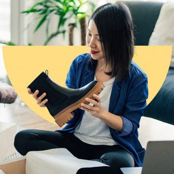 design element of a women sitting on a couch in a living room holding a boot