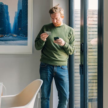 Man making an online payment on his smartphone using his credit card