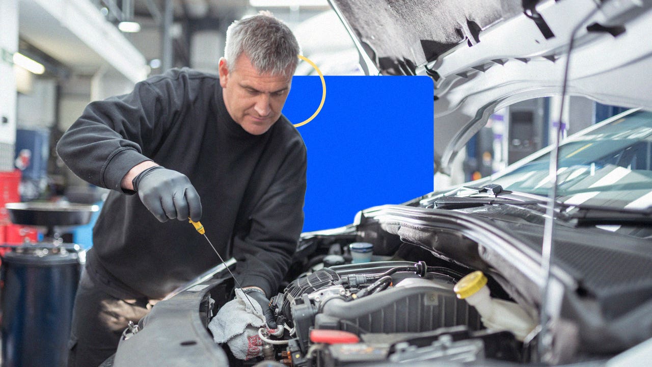 A mechanic works on a car.