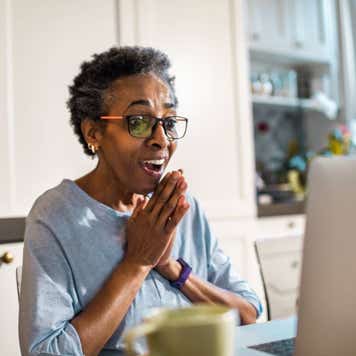 Happy woman reacting to news from her laptop
