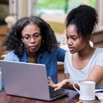 Mature woman helps her daughter study for exam