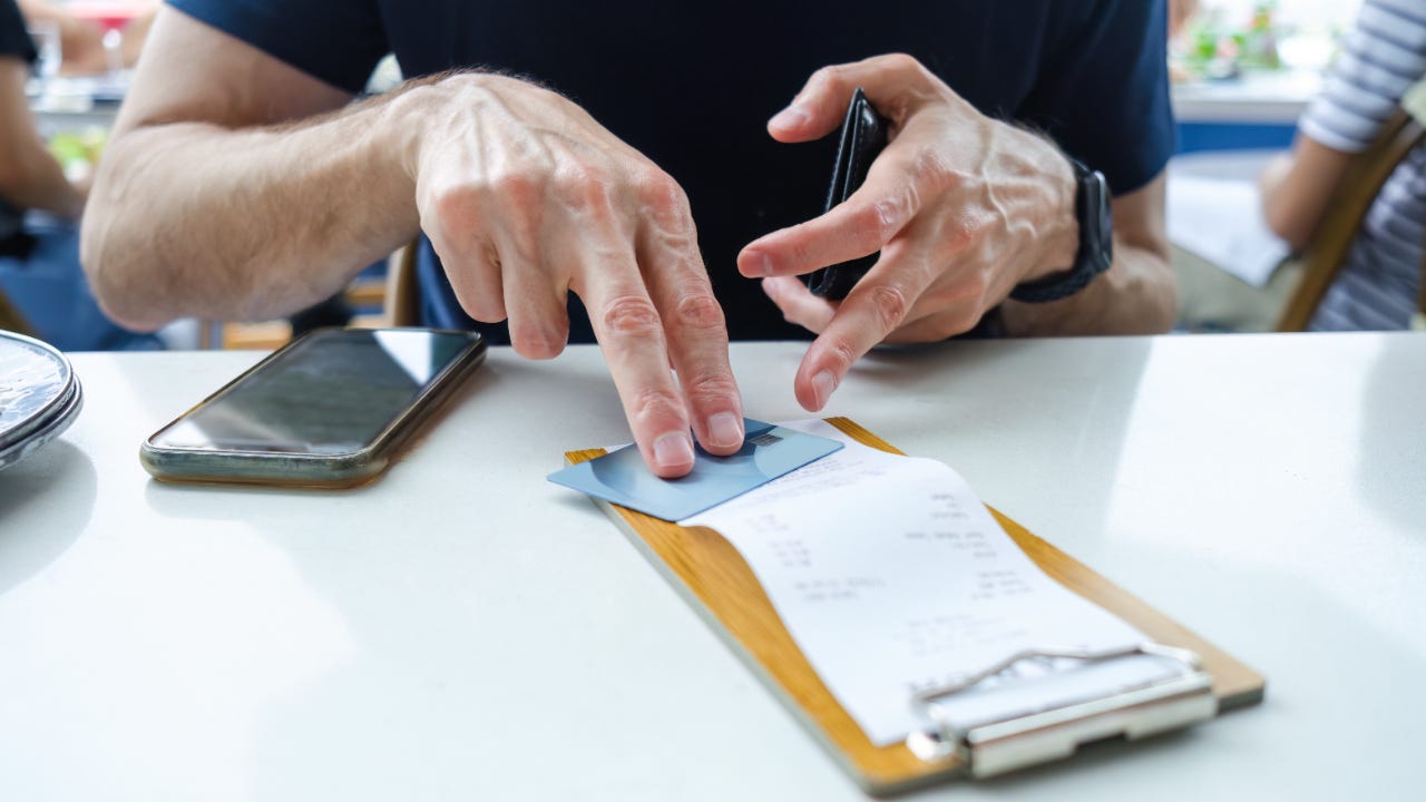Man Prepares to Pay Restaurant Bill With Credit Card