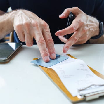 Man Prepares to Pay Restaurant Bill With Credit Card