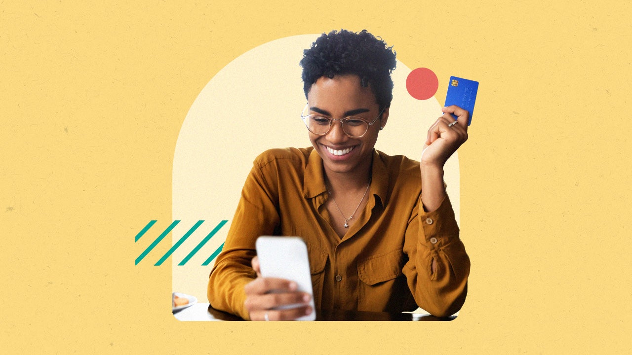 Person on a cellphone holding a credit card