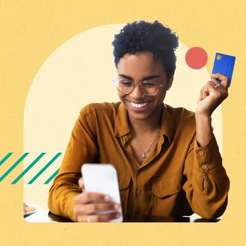 Person on a cellphone holding a credit card