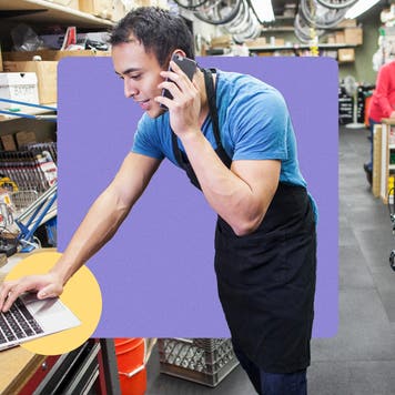 Man reviewing laptop while on the phone.
