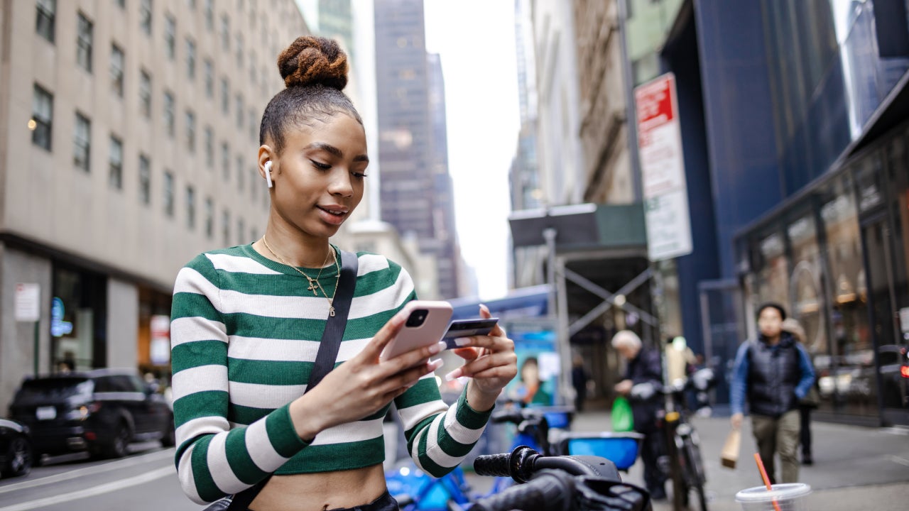 Young woman paying for a bike ride on the street