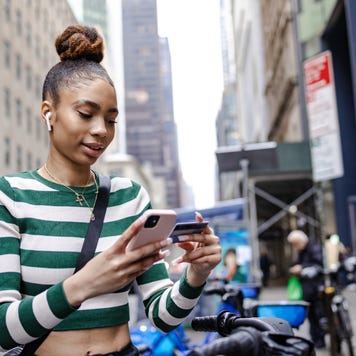 Young woman paying for a bike ride on the street