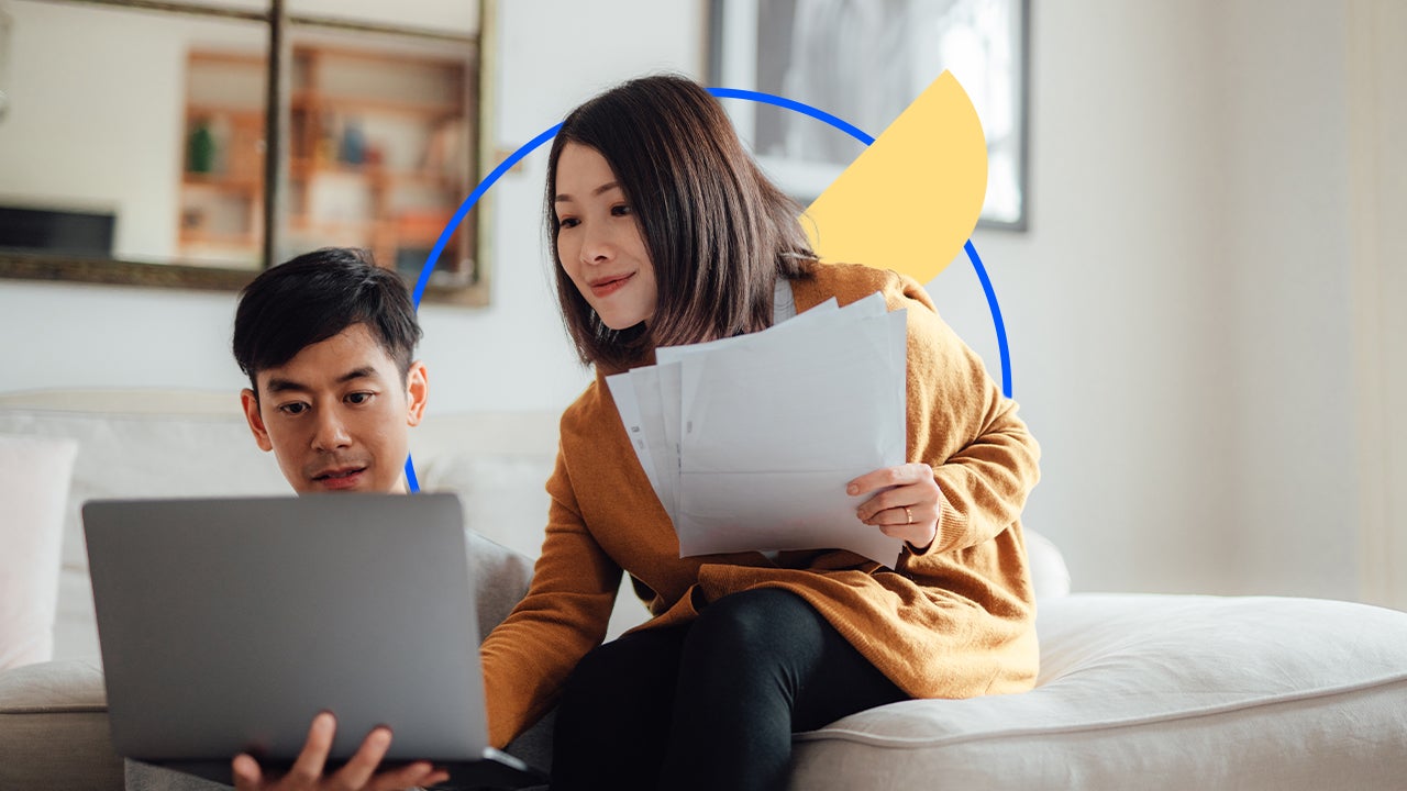 Two people going over documents on a laptop