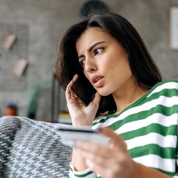 Concerned lady talking on smartphone having finance stolen from card