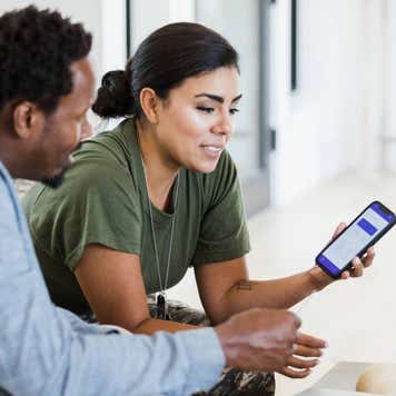 female soldier and her husband use a banking app to check the state of their finances