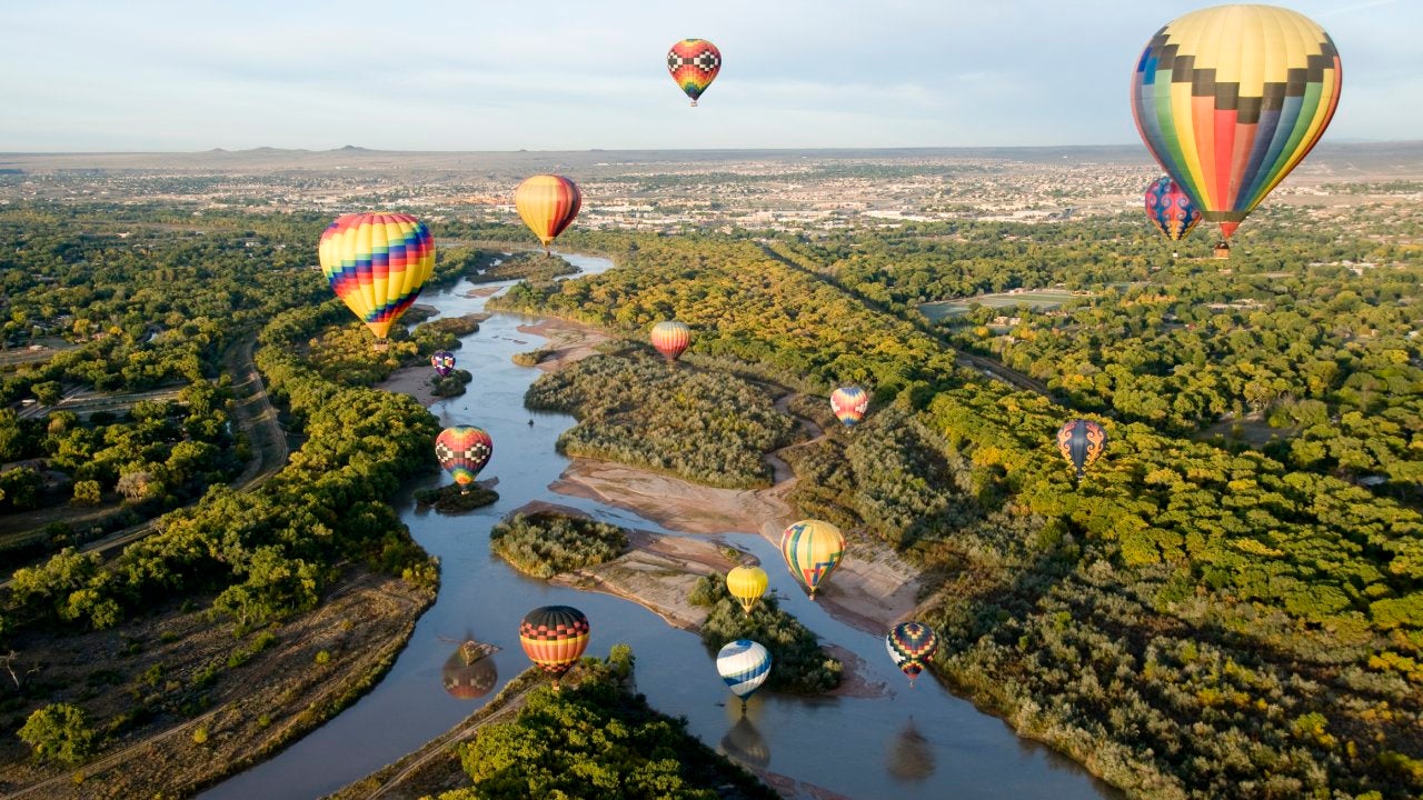 Hot air balloons drifting over the Rio Grande river in Albuquerque, New Mexico.