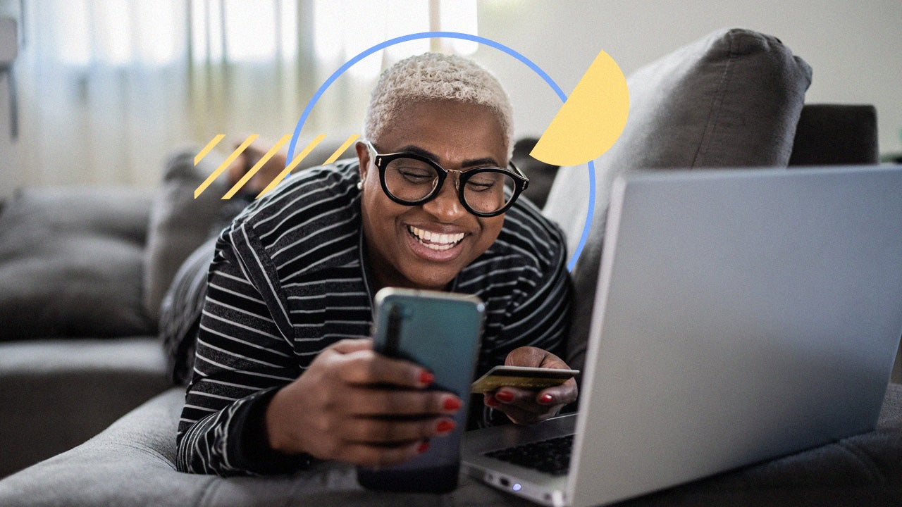 Person holding credit card while working on a laptop