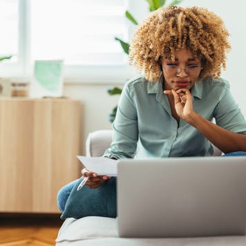 Person working on a computer on an office couch and drinking tea