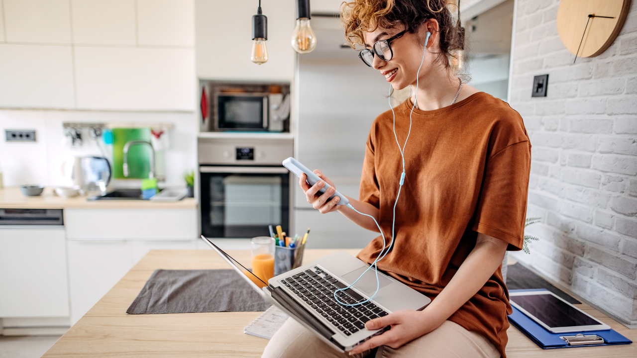 young white woman with red hair working on laptop in kitchen