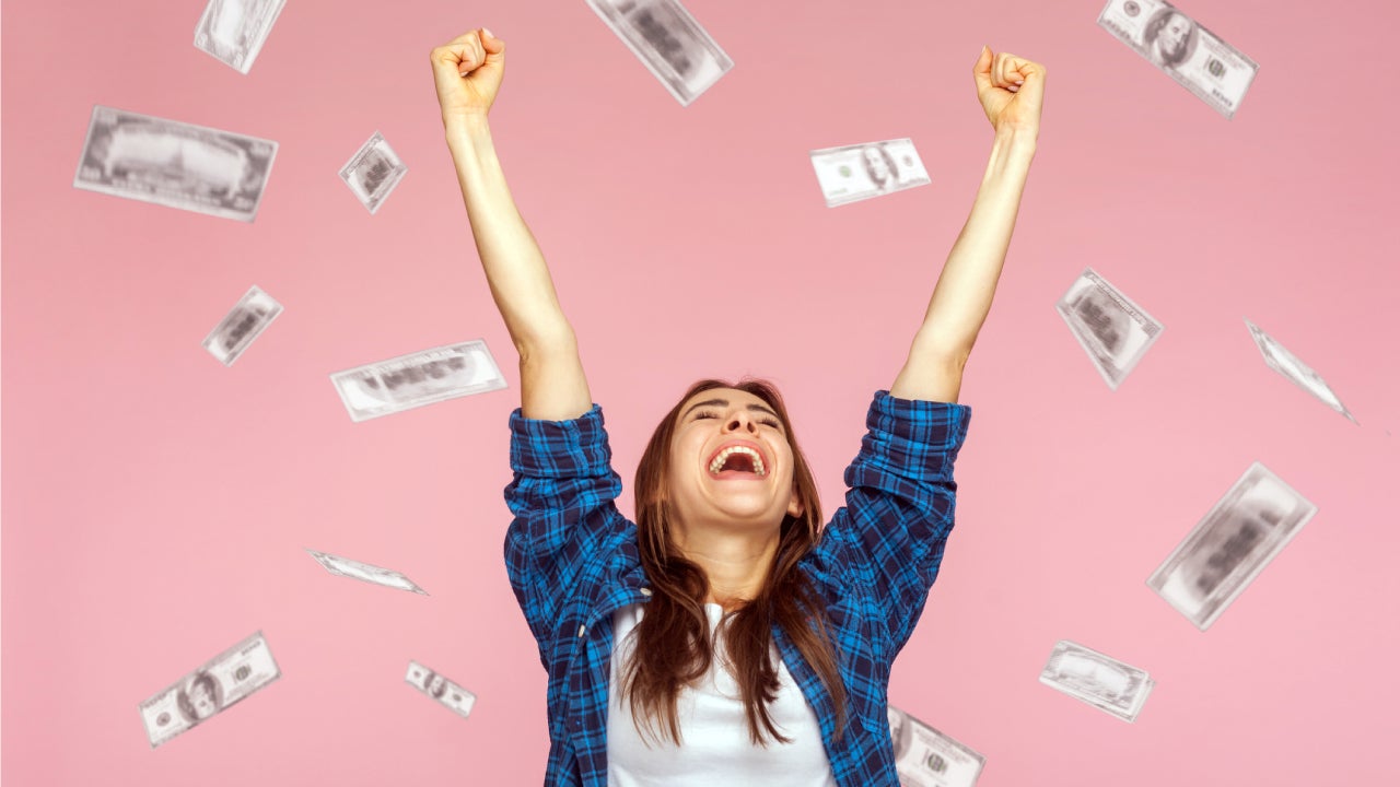 Money rain, woman rising hands up with toothy smile on face