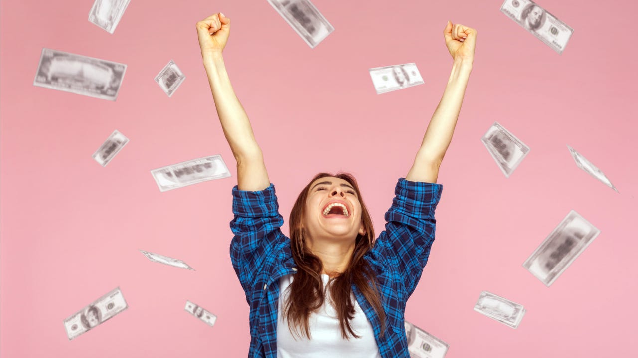 Money rain, woman rising hands up with toothy smile on face