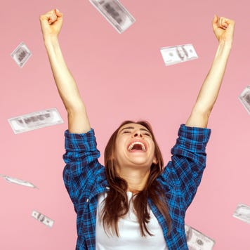 Money rain, woman rising hands up with toothy smile on face