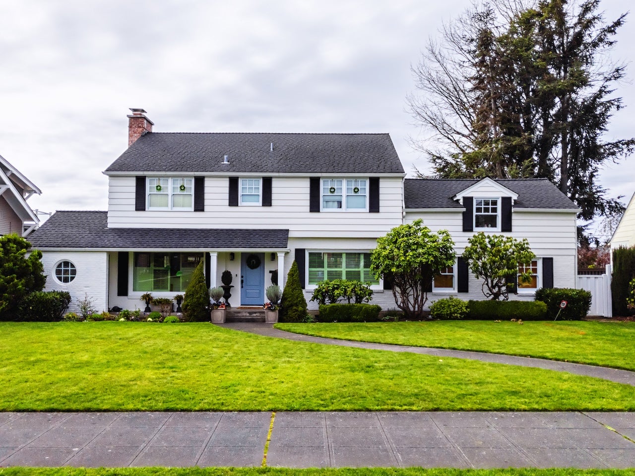 large white colonial style house exterior, green grass