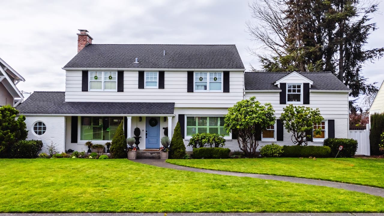 large white colonial style house exterior, green grass